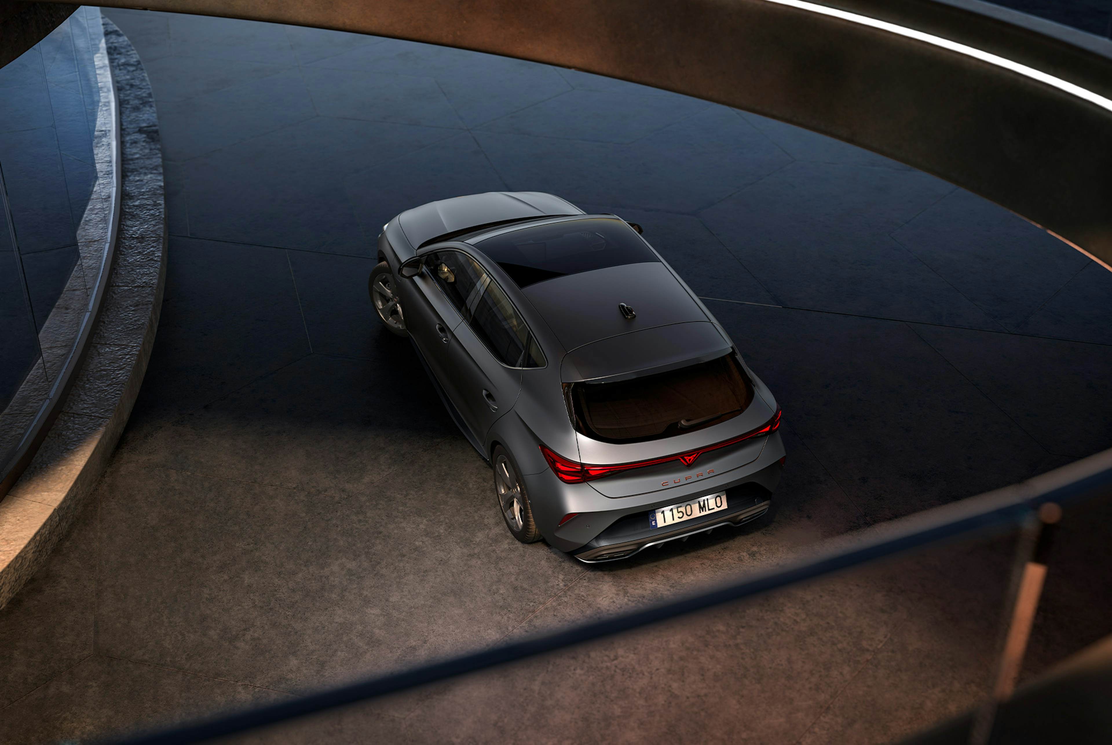 versions et équipements de la nouvelle Cupra Leon 2025, prises d’air, phares au dessin triangulaire, coucher de soleil, panneaux de verre, architecture et ciel bleu.